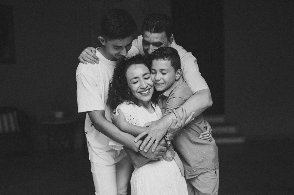 Black and white portrait of a joyful family embracing in a warm group hug.