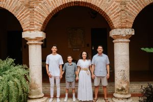 Family standing together under rustic brick archways with stone columns.