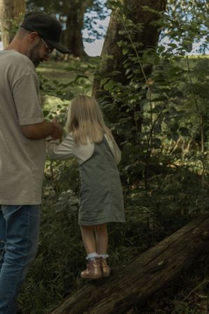 Adult and child exploring nature together on a forest trail.