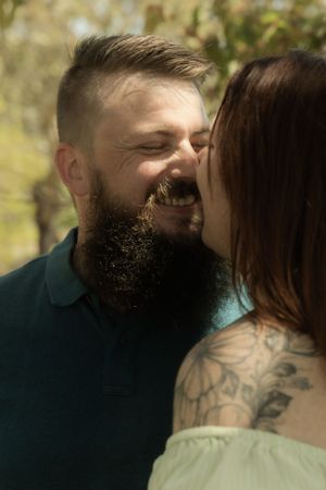 Intimate moment between couple sharing affection outdoors in natural lighting.