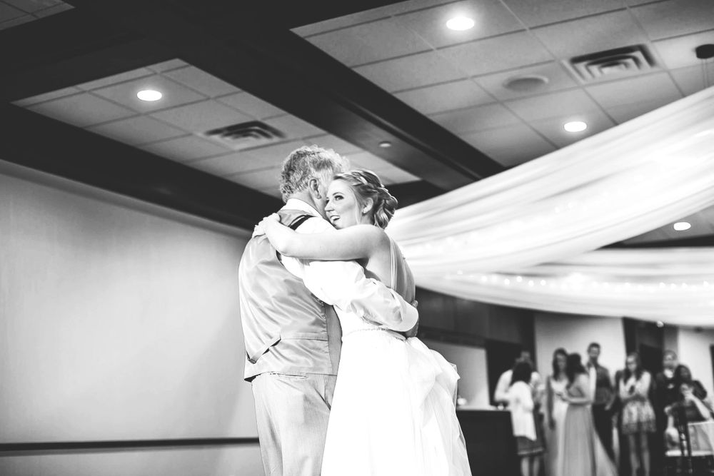 Black and white photo of bride and father sharing emotional wedding dance.