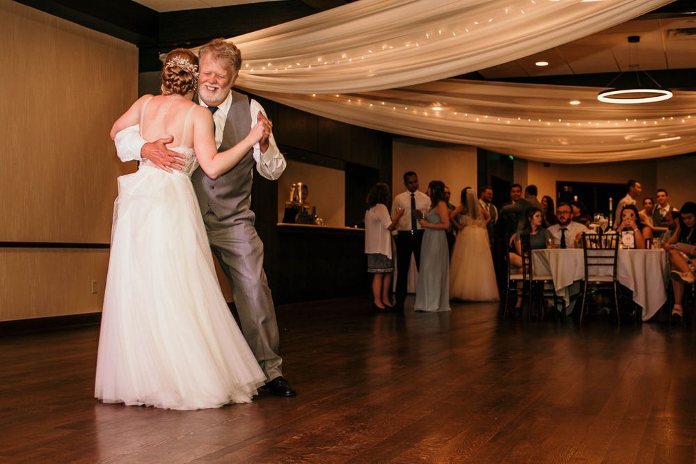 Bride and father share tender dance moment at elegant wedding reception.