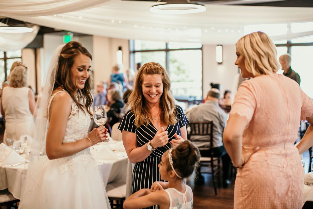 Adorable young boy in white shirt smiling joyfully at a wedding celebration.