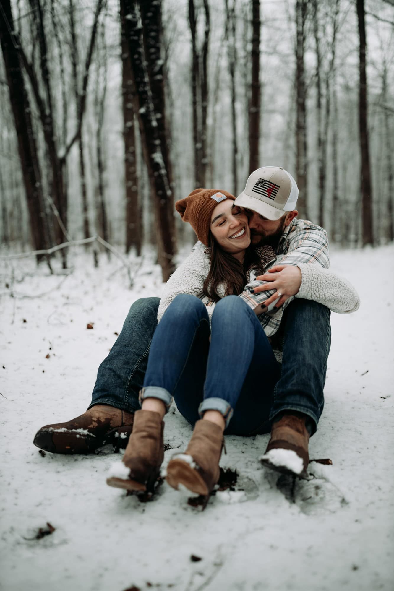 Couple-sitting-in-snow-oak-openings