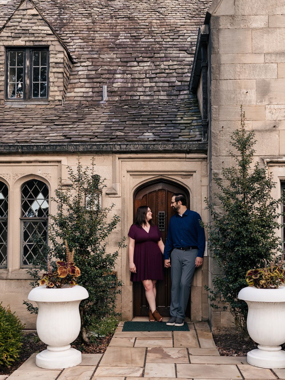 A couple stands in front of a gothic stone building with white planters and arched doorways in a progressive sequence.