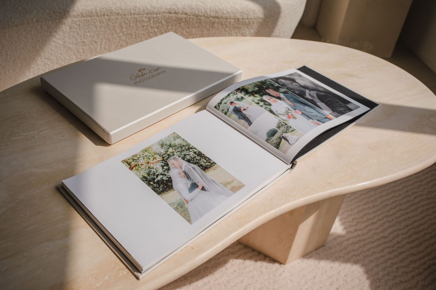 Open wedding photo album displaying professional photographs in clean minimal layout.