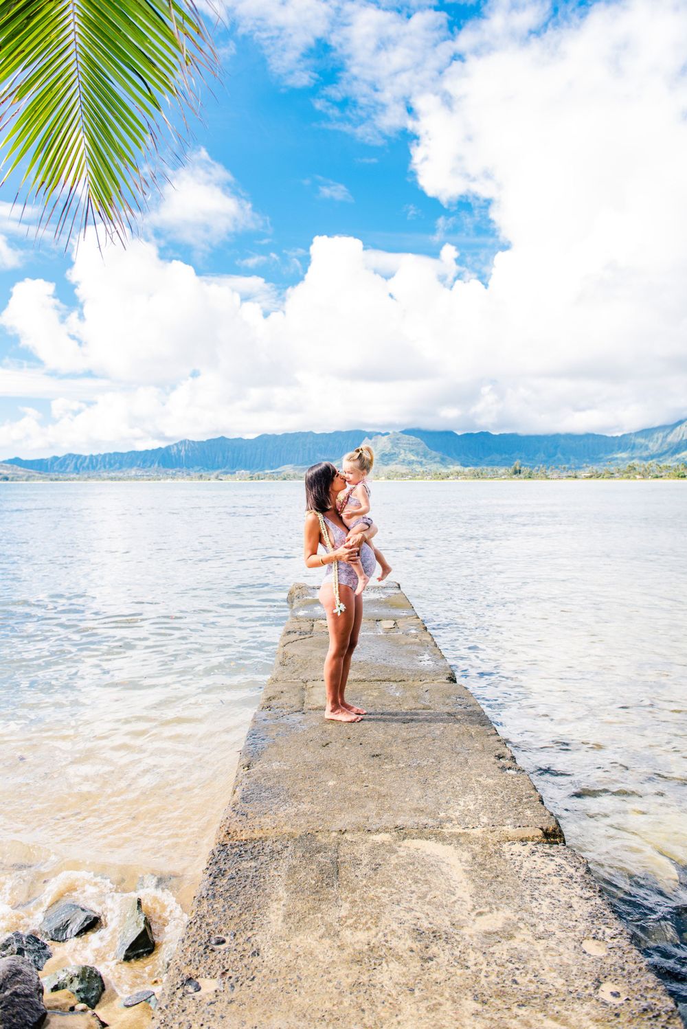 Maternity photos in Oahu with ocean and mountains backdrop.