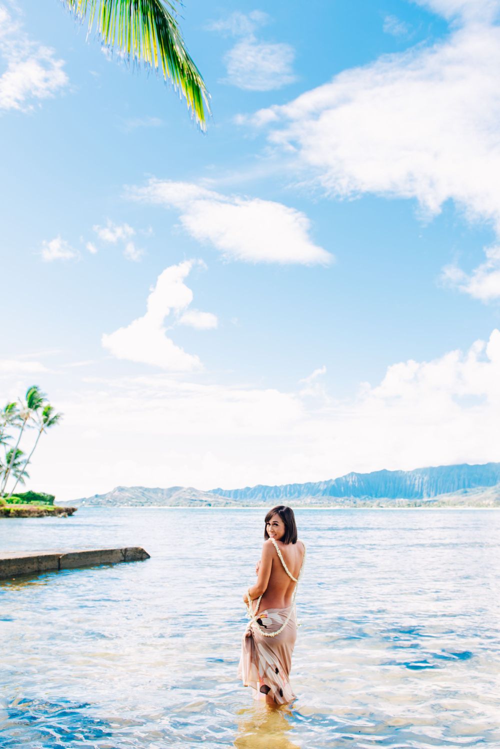 Maternity photos in Oahu with ocean and mountains backdrop.