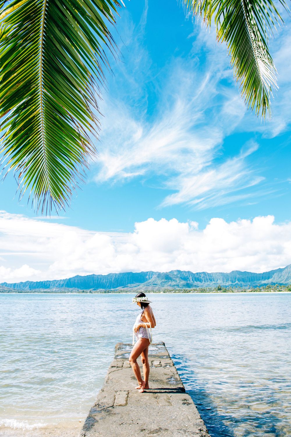 Maternity photos in Oahu with ocean and mountains backdrop.