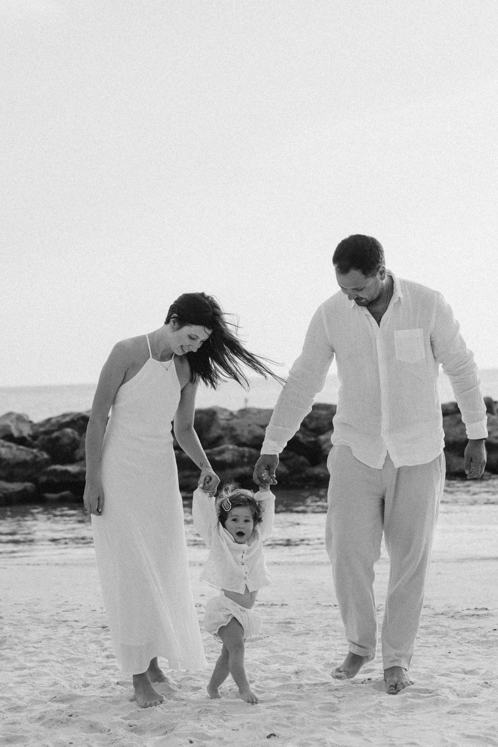 Black and white photo of a family playing together on the beach.