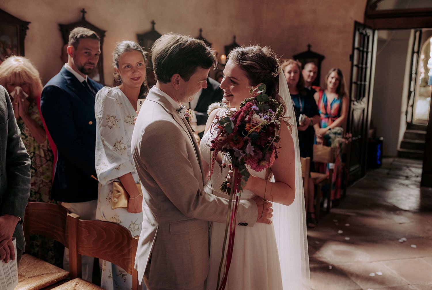 An emotional wedding ceremony moment in a rustic indoor venue.