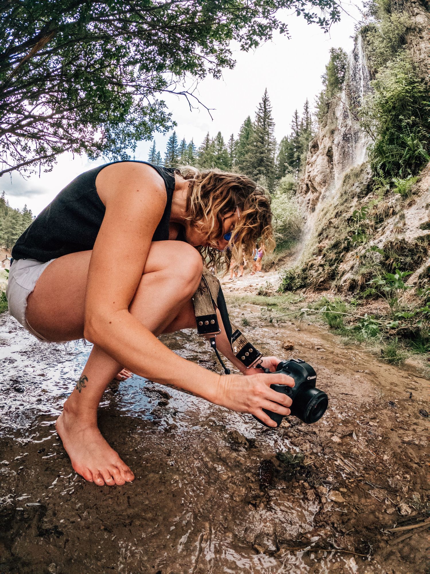 woman crouching down taking photos with camera