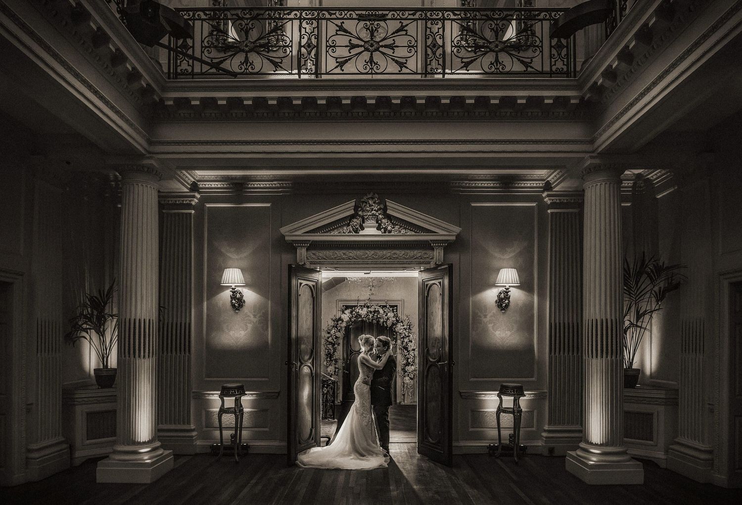 Dramatic black and white architectural wedding venue interior with ornate details.