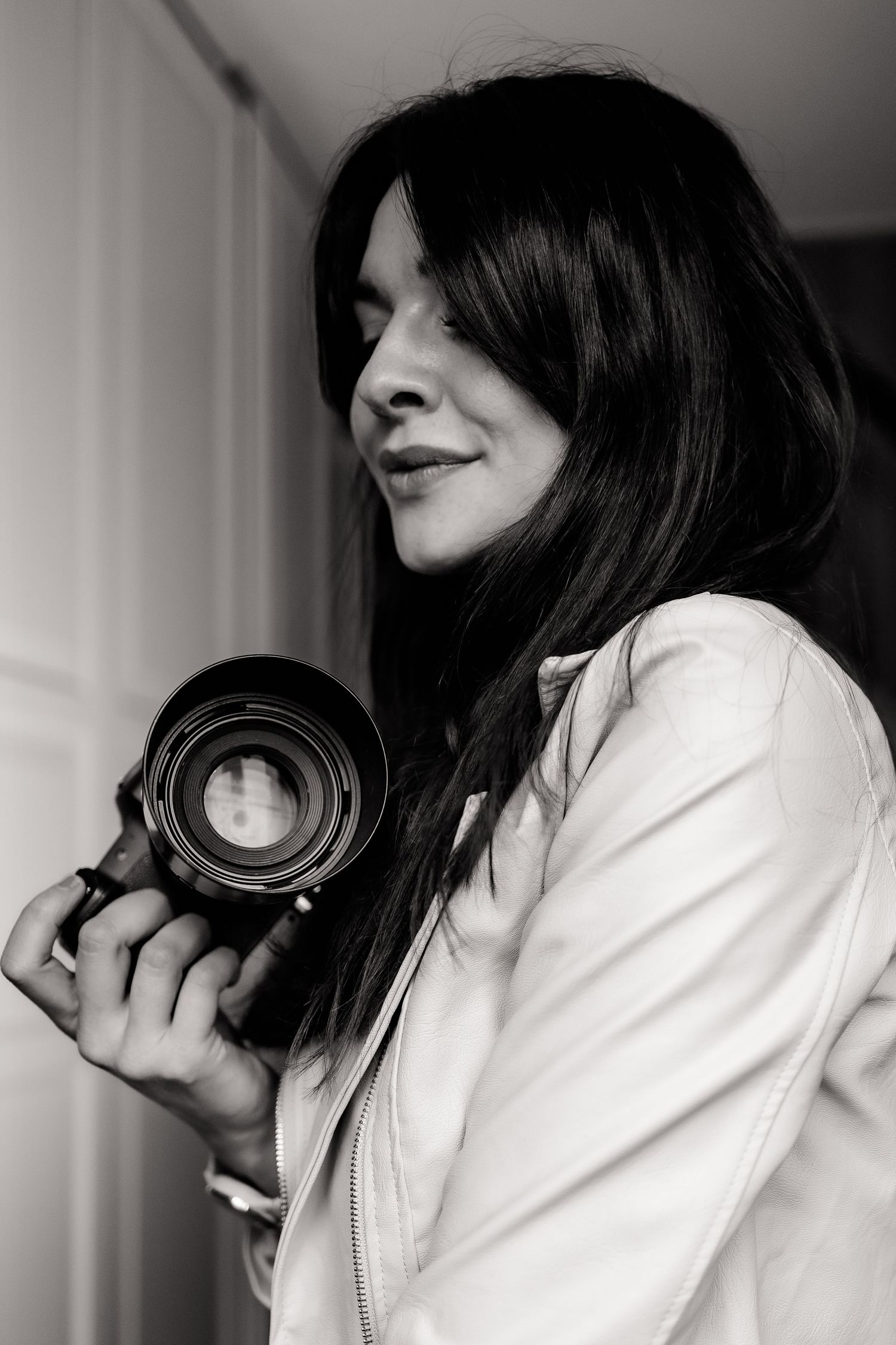 Portrait of photographer holding professional camera lens in black and white.