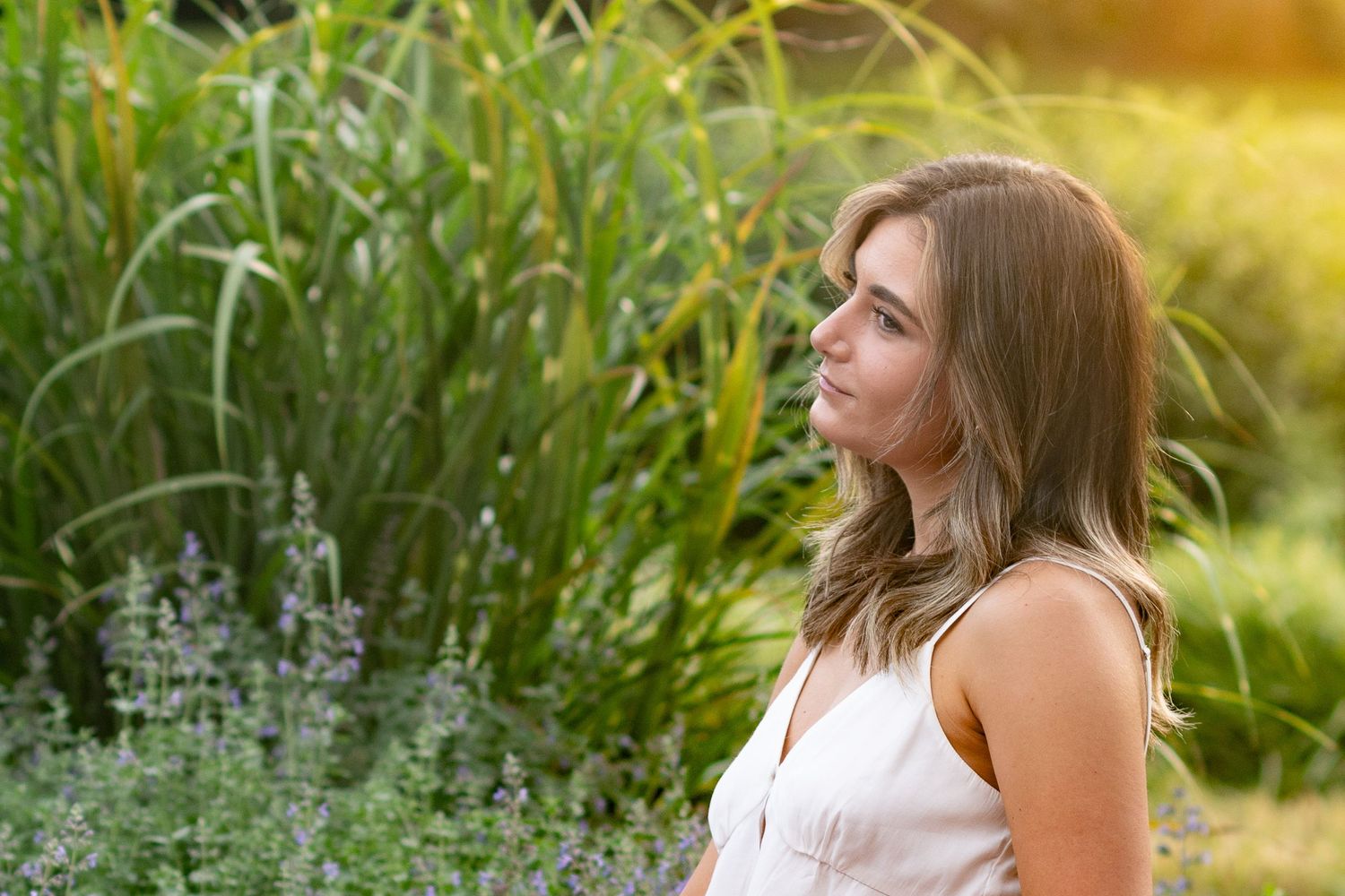 Professional outdoor portraits with soft sunlight filtering through lush green vegetation.