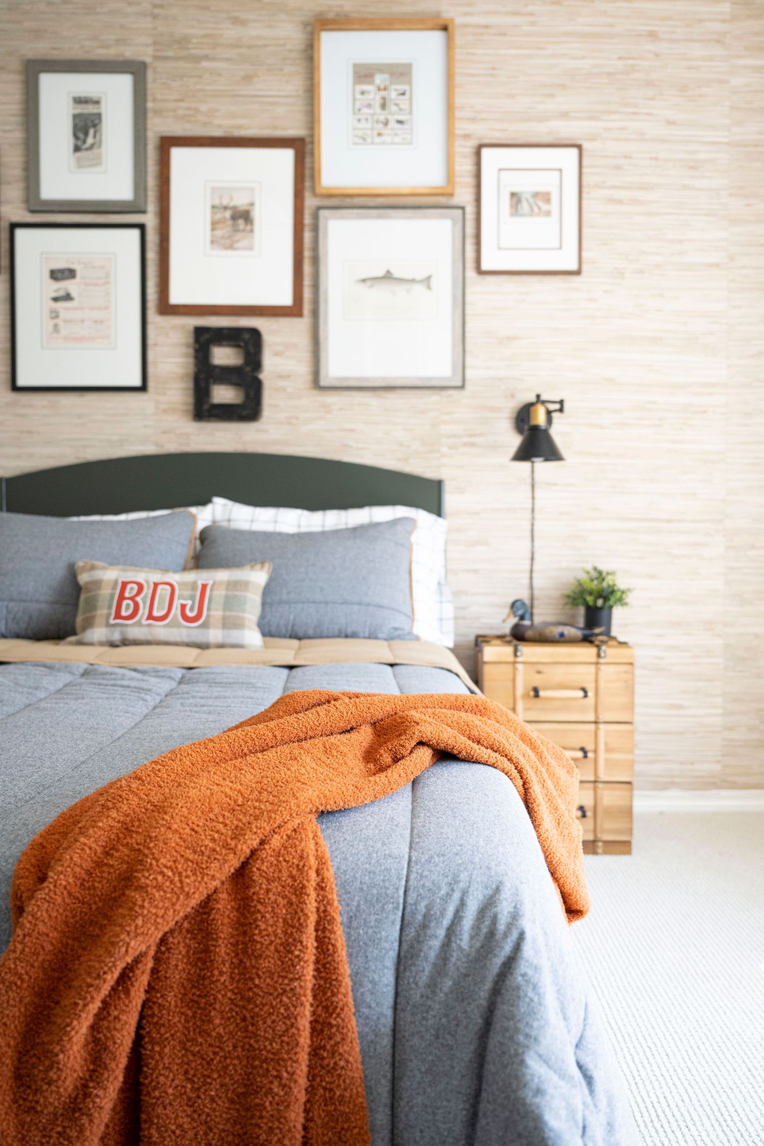 Cozy bedroom featuring gallery wall, blue bedding and burnt orange throw blanket. Interior Design, NJ Photo