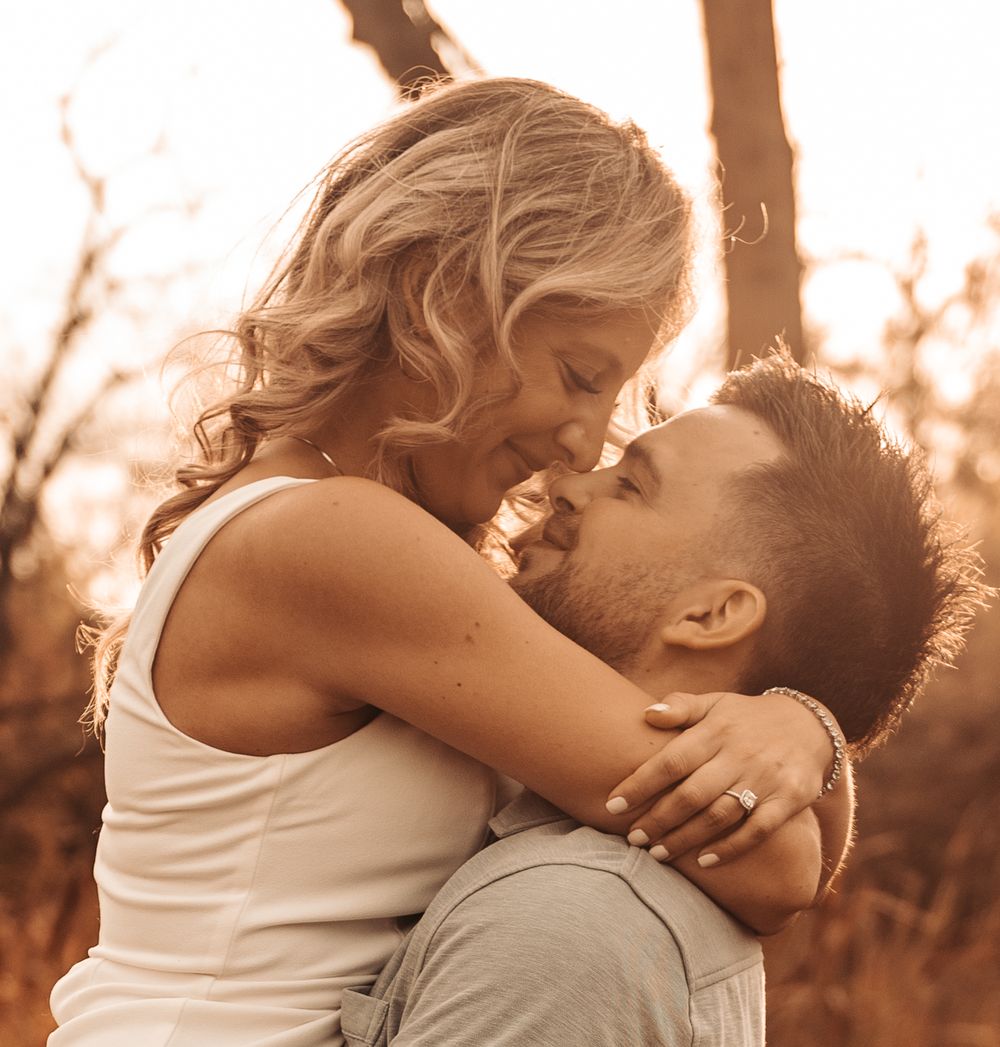 Romantic sunset portrait of couple embracing in warm golden light.