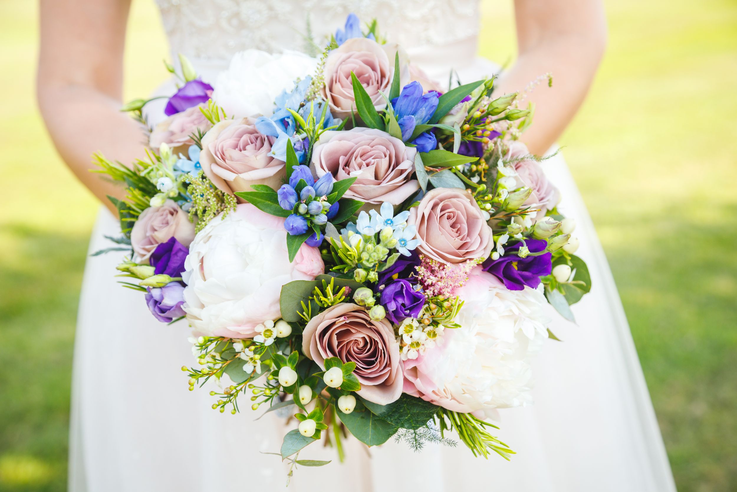 Bright wedding bouquet blues and pinks roses in summer taken at Rookery Spa Cheshire