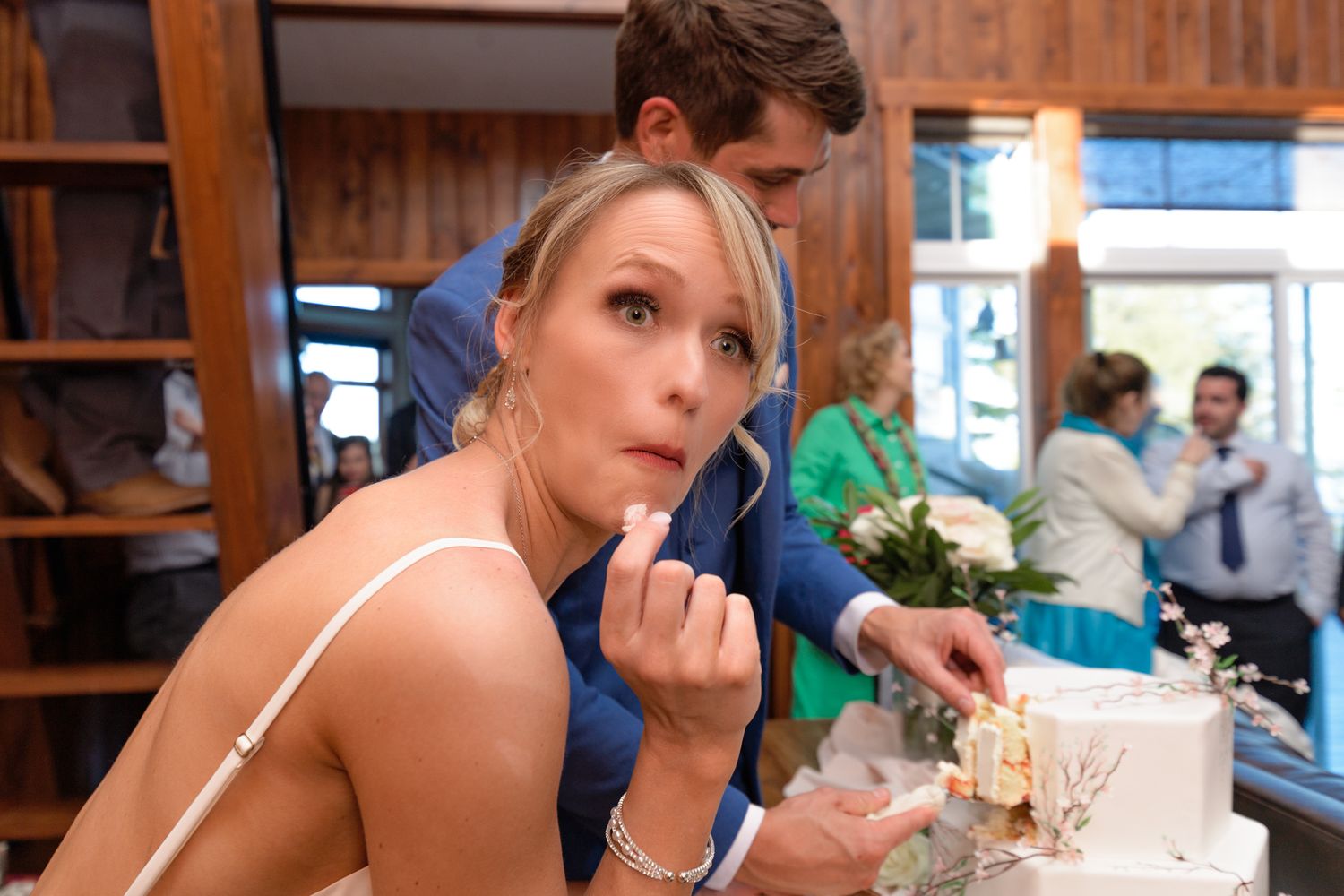 A woman touching up her makeup during a celebration in a rustic wooden interior.