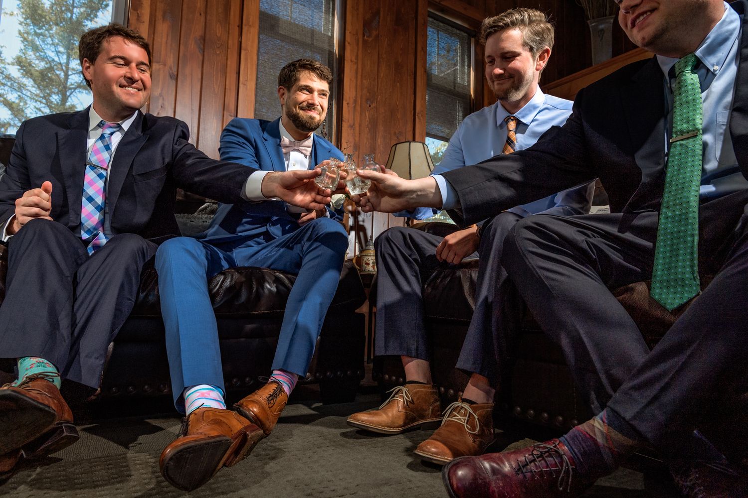 Group of formal dress shoes and legs gathered in a circle for celebratory toast.