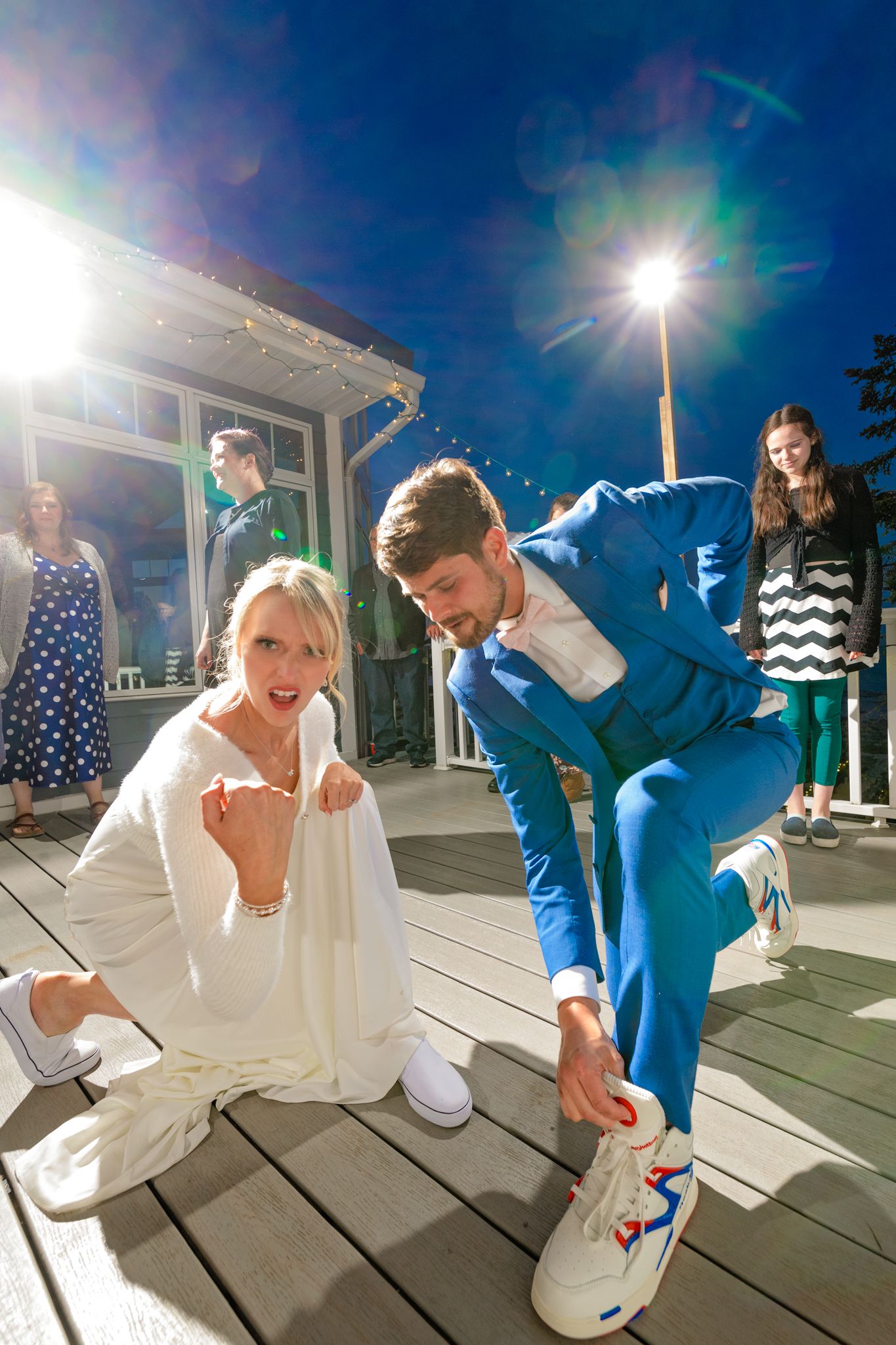 Energetic dance moves on outdoor deck with bright sunlight and string lights overhead.