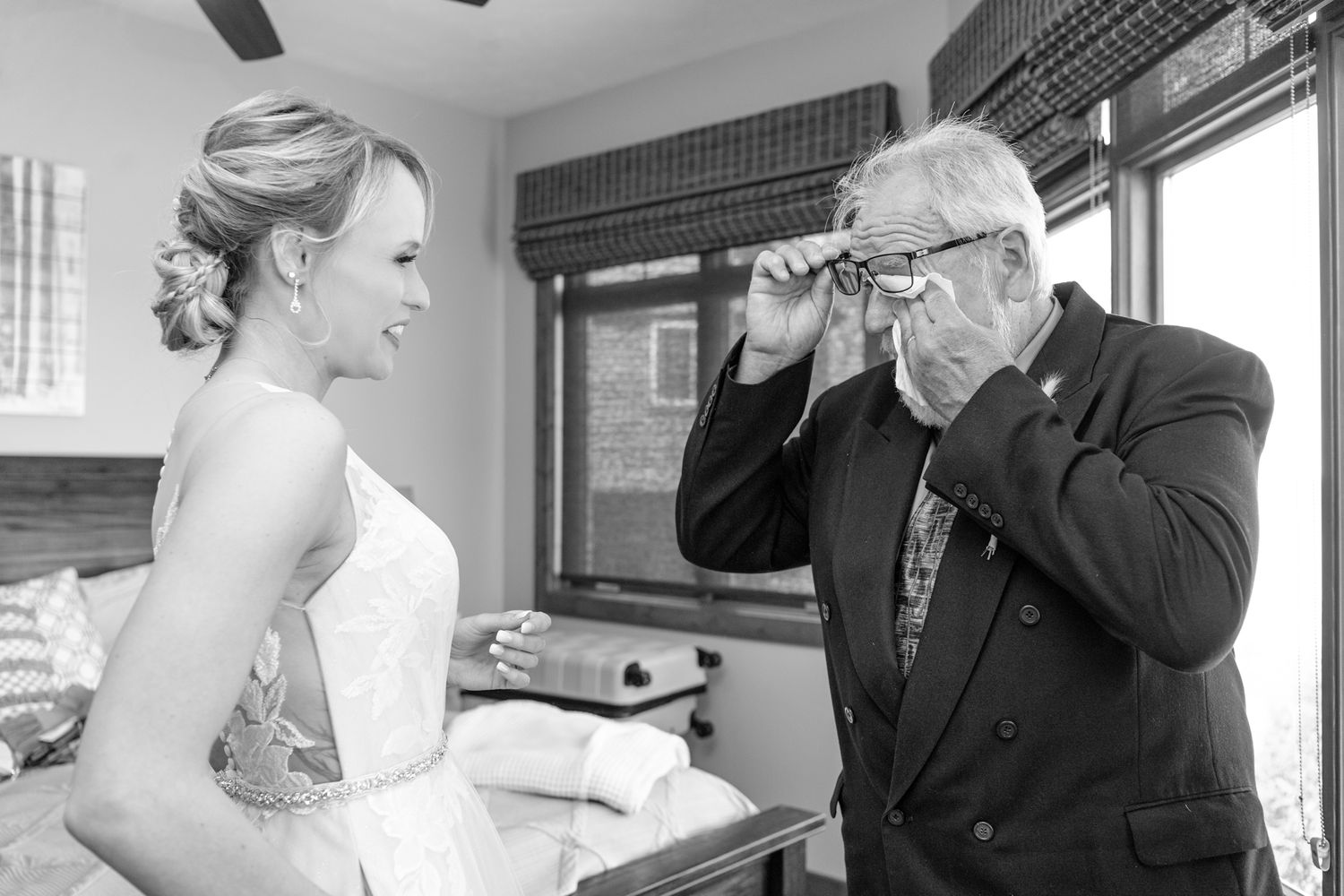 Black and white photo of emotional first look reaction in wedding attire.