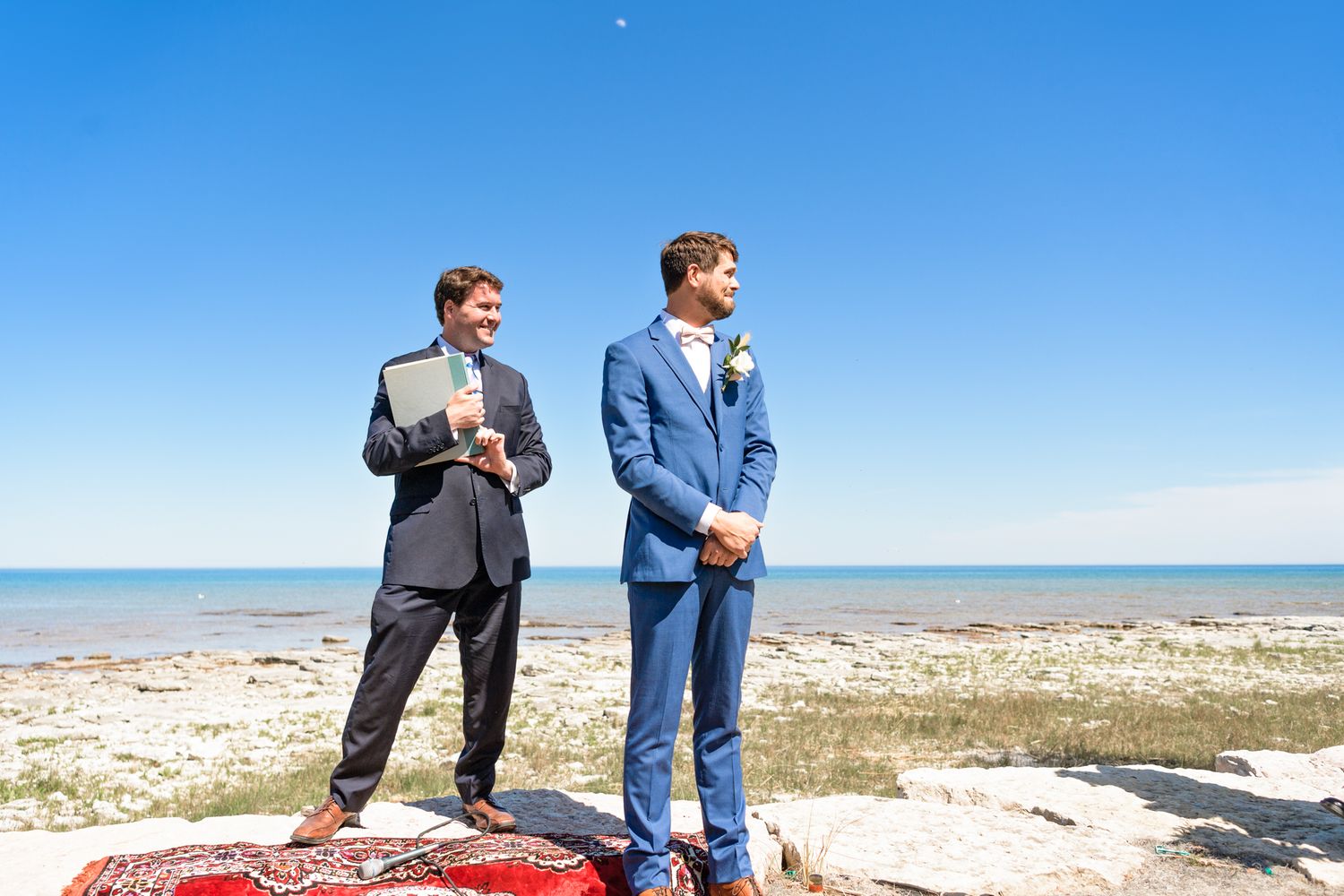 Beachside wedding ceremony setup with red carpet and ocean backdrop.