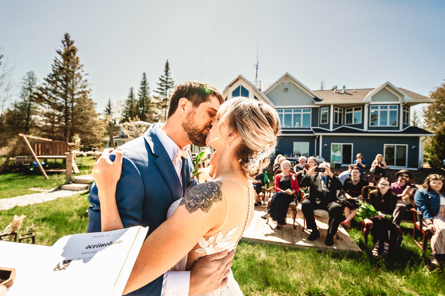Couple shares intimate moment during wedding ceremony with guests in background.
