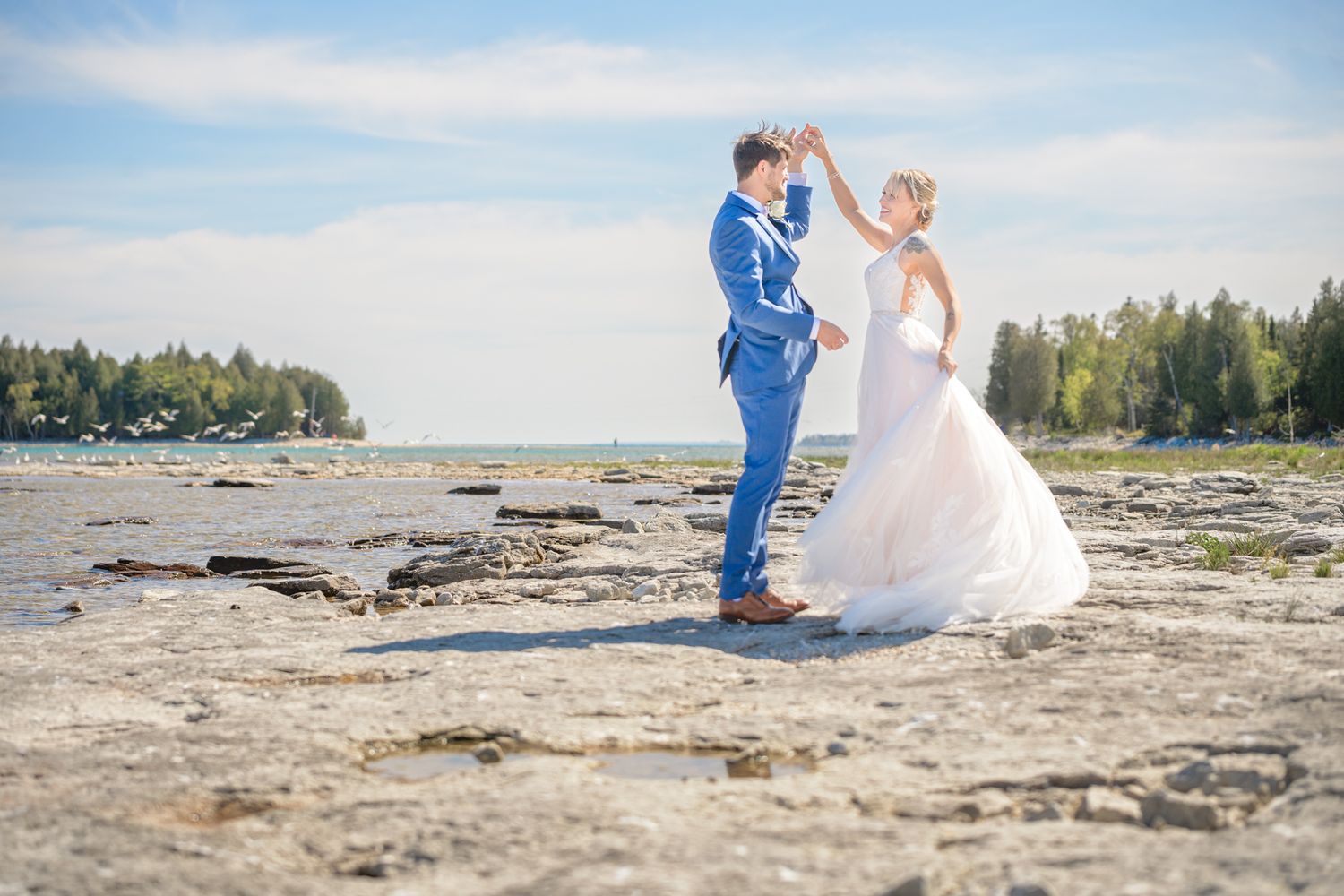 Wedding couple sharing an intimate moment on a rocky beach landscape.