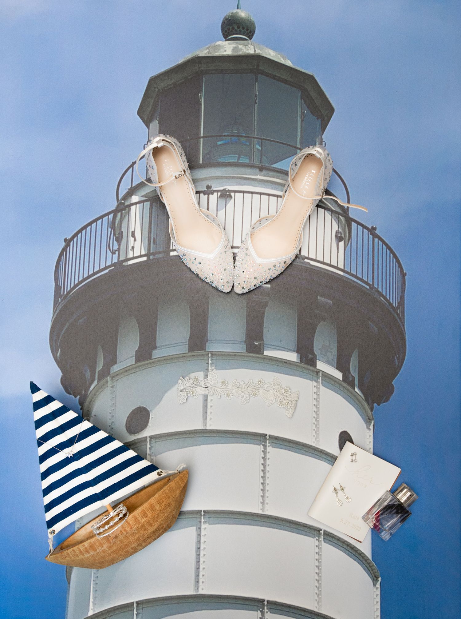 White lighthouse tower with nautical decorations against blue sky.