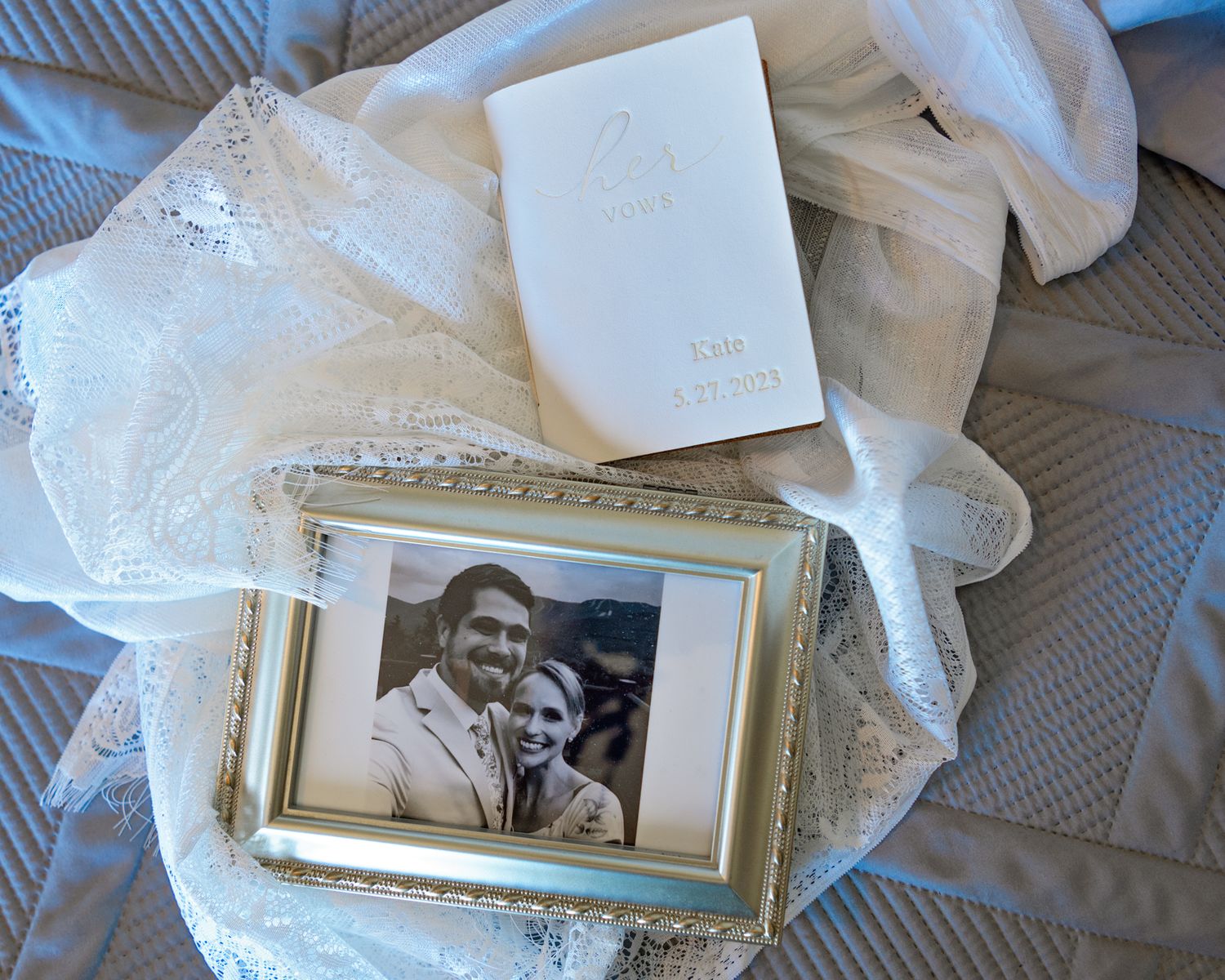 Wedding memorabilia and framed photograph arranged on white fabric.