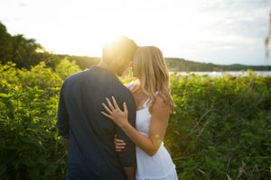 A romantic sunset moment between a couple in a field of wildflowers.