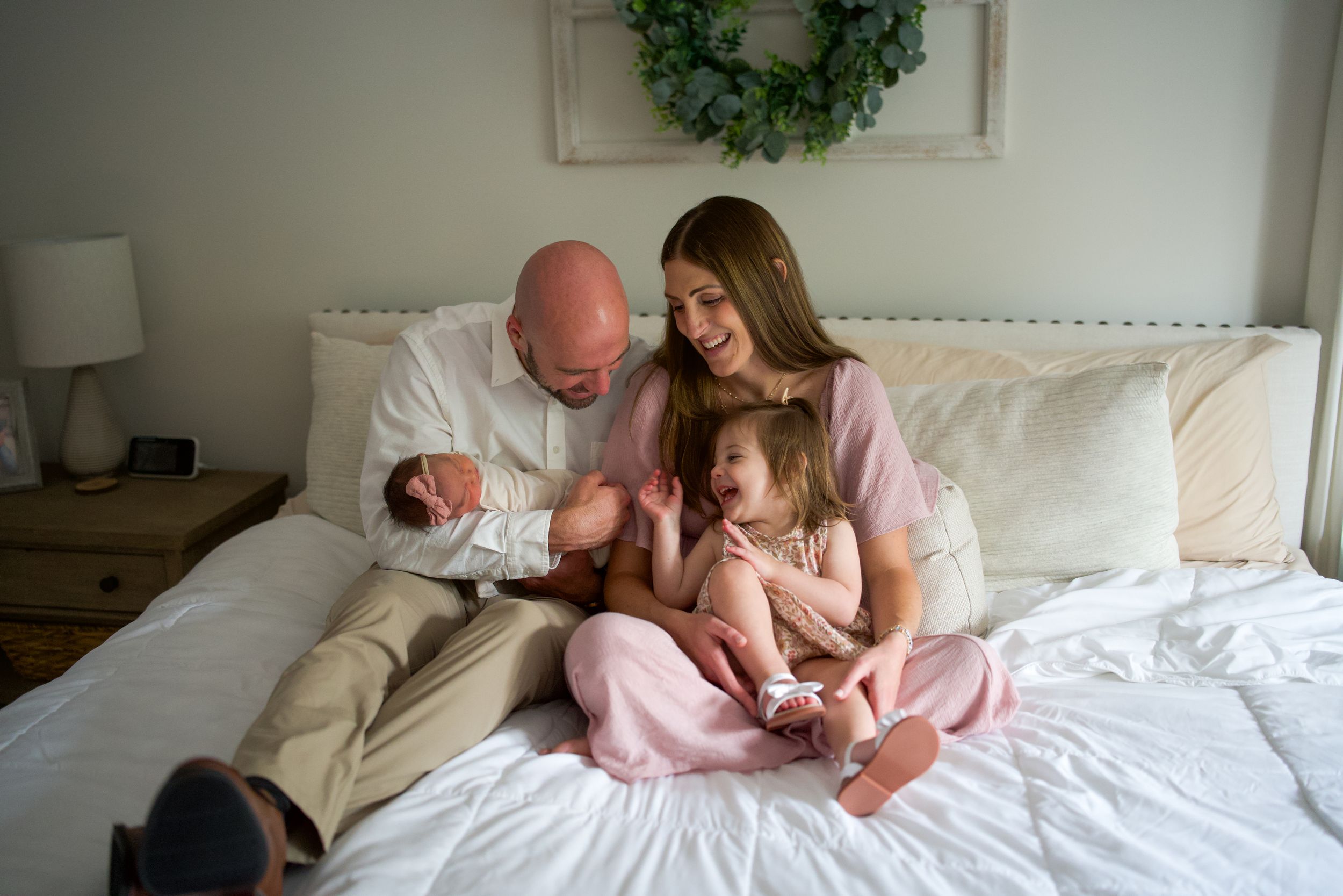 Couple relaxing together on white bedding while sharing intimate moments in a cozy bedroom setting.