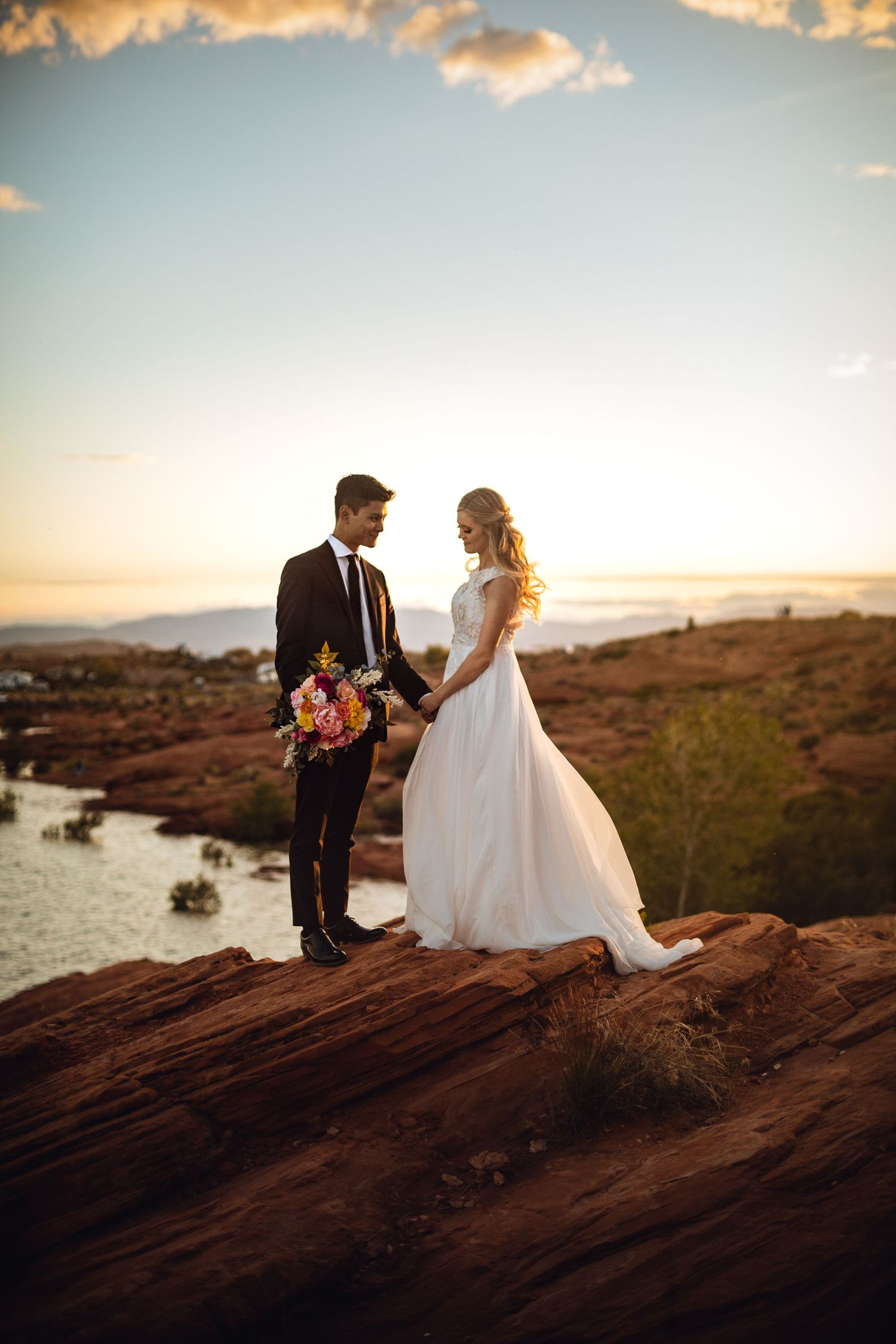 Adventure bride and groom in St George on Red rock in from of Sand Hollow State Park and Zion National Park.