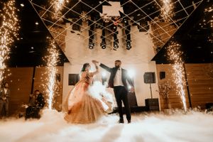 Dancing couple surrounded by sparklers and fog effects during their wedding celebration.
