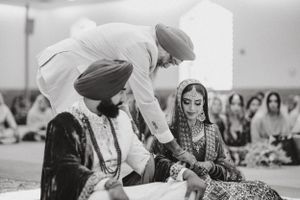 Black and white photo of traditional Sikh wedding ceremony.