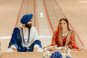 Traditional Sikh wedding couple seated together in ceremonial attire during marriage ritual.