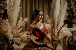 Wedding scene with pampas grass decor and traditional Indian bridal attire.