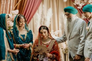 Traditional Sikh wedding ceremony with guests and family gathered around the couple.