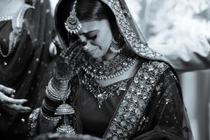 Black and white portrait of bride in traditional Indian wedding attire and jewelry.