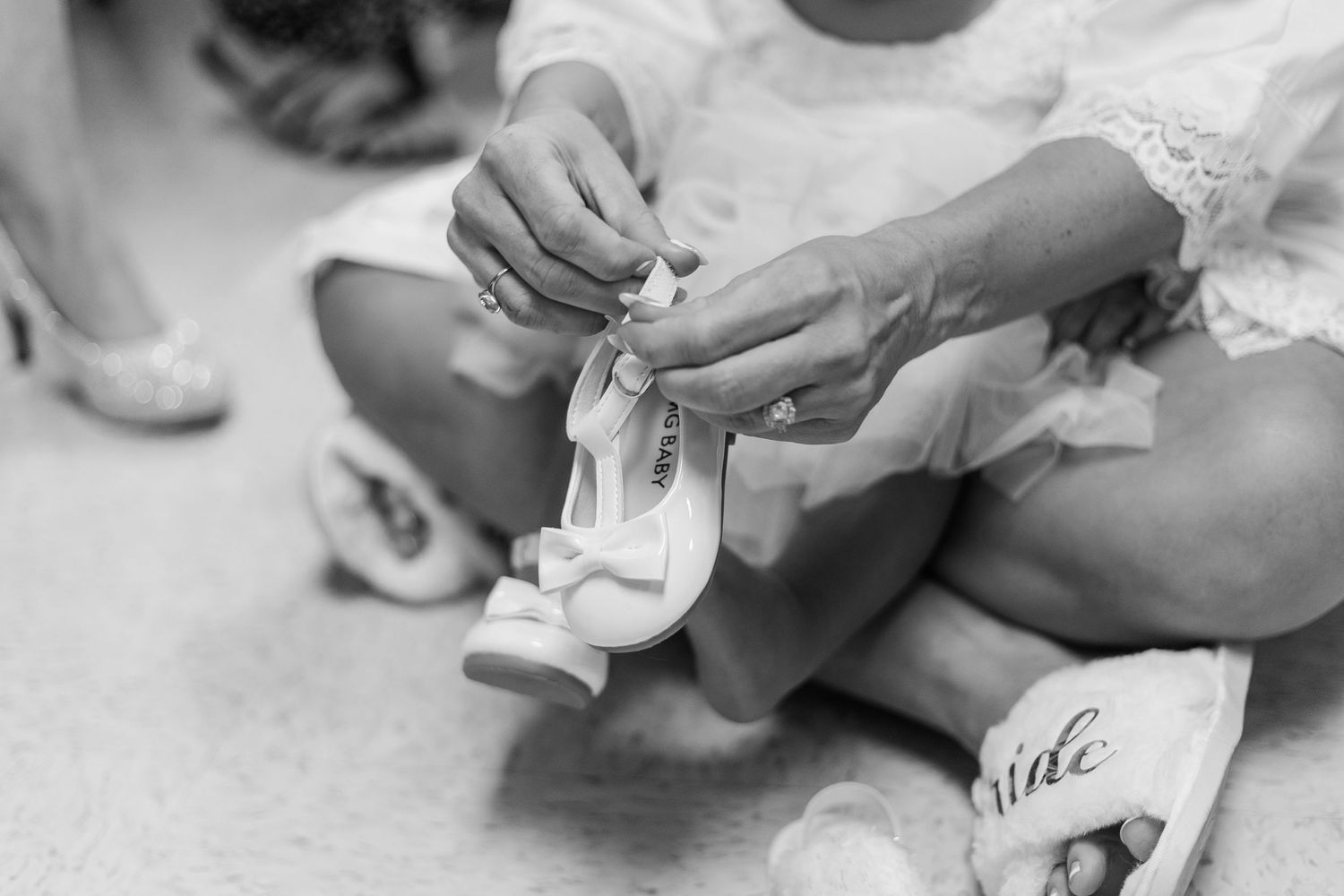 Close-up details of wedding preparations showing hands working with delicate items.