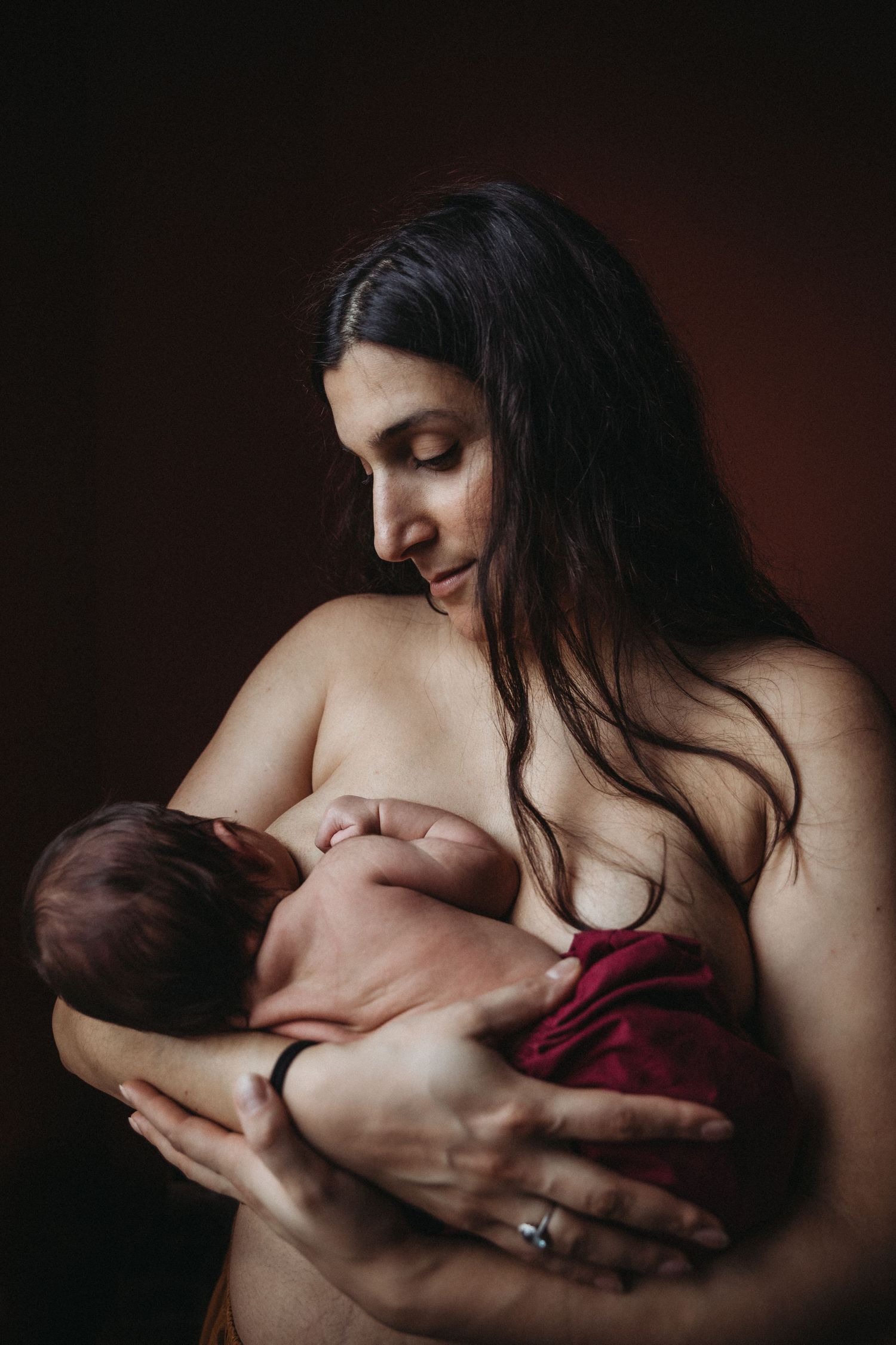 mum breastfeeds newborn baby in fine art portrait by newborn photographer london sarah stirk
