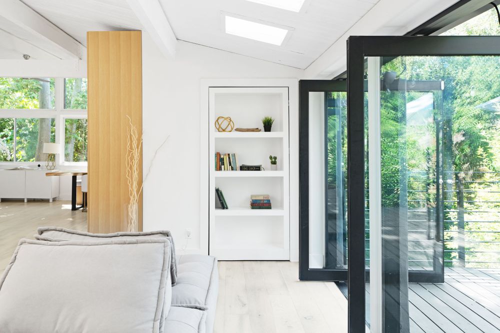 Bright interior space with floor-to-ceiling windows and built-in shelving in modern design.