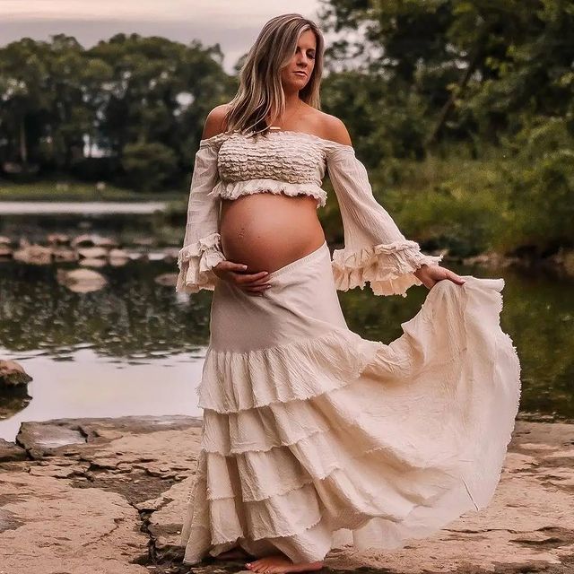 Flowing white ruffled dress photographed in a romantic outdoor setting by a lake.