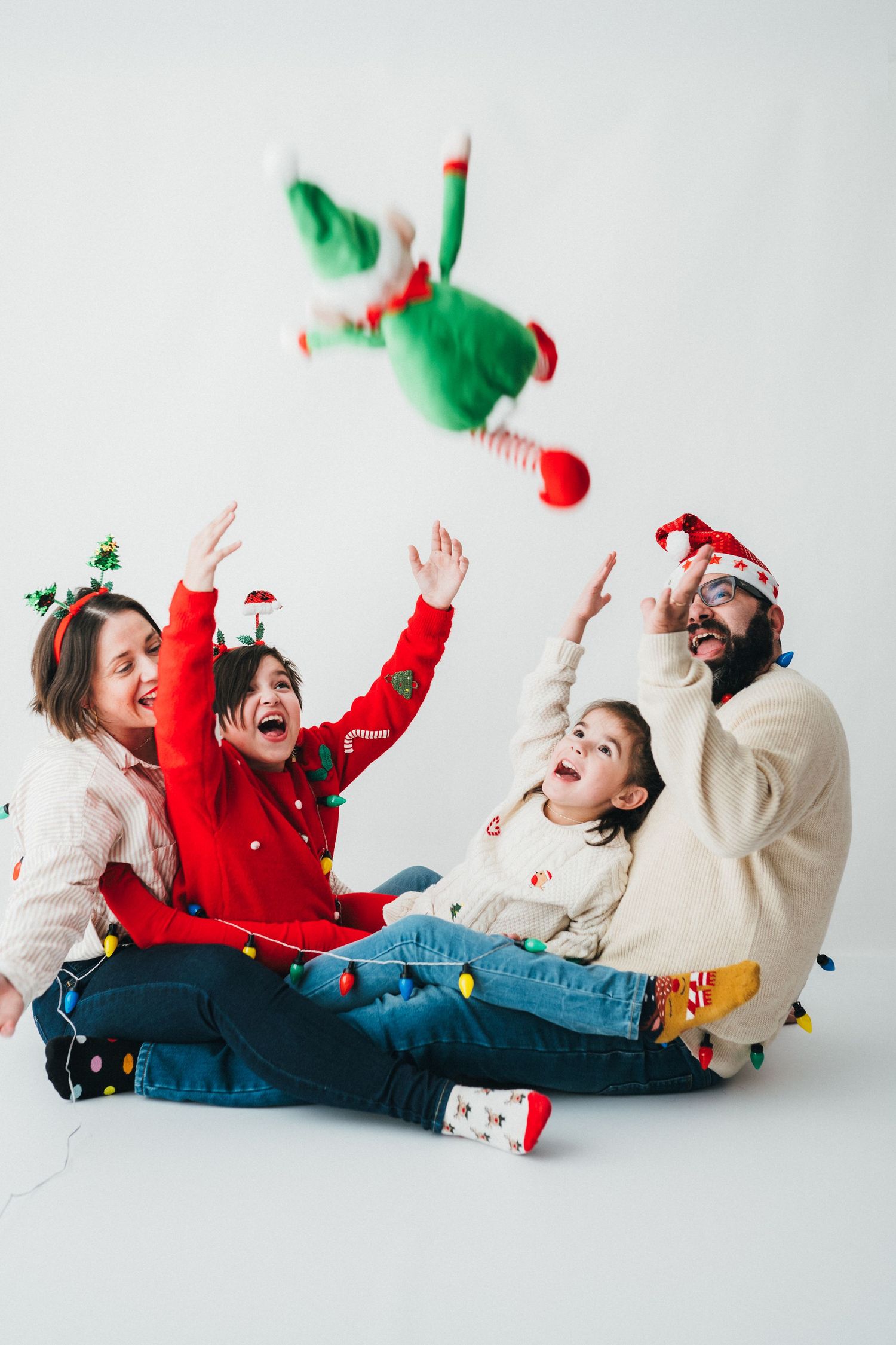 Une famille rit et joue ensemble pendant une mini-séance photo de Noël au studio Mon Amour des Photos à Fameck, près de Thionville et Metz.