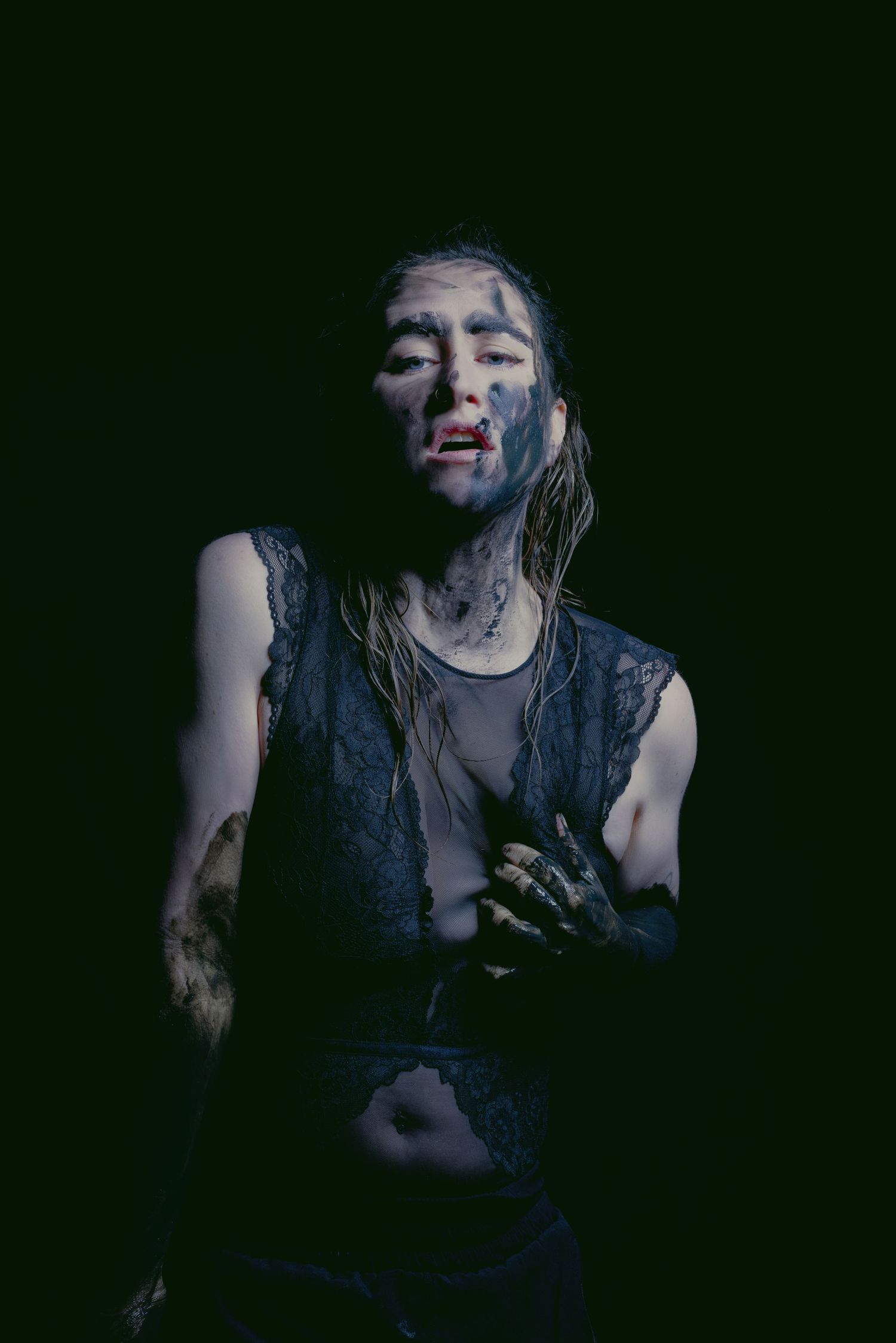 Moody low-key portrait series in dark setting with dramatic lighting effects.