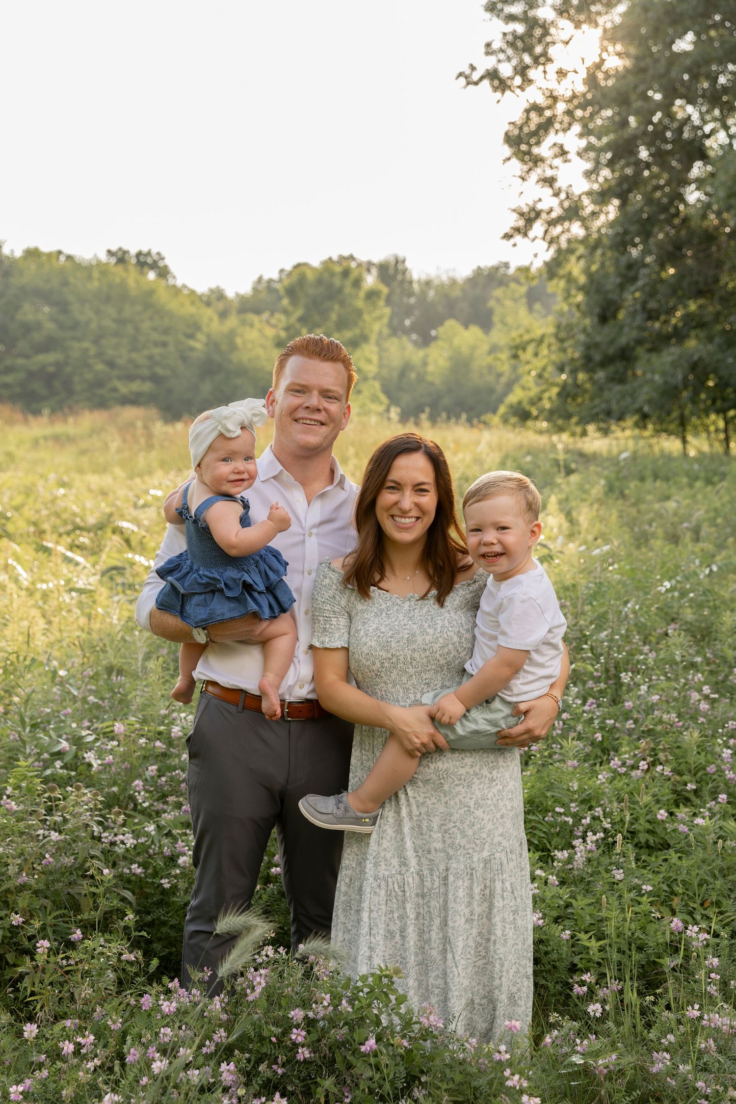family of four standing in a field of grasses and flowers at Douglas Evans nature preserve in Beverly Hills Michigan