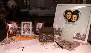Wedding reception table with vintage photographs and memory displays.