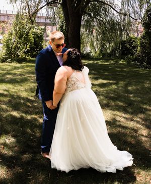 Romantic wedding couple shares intimate moments under a willow tree.