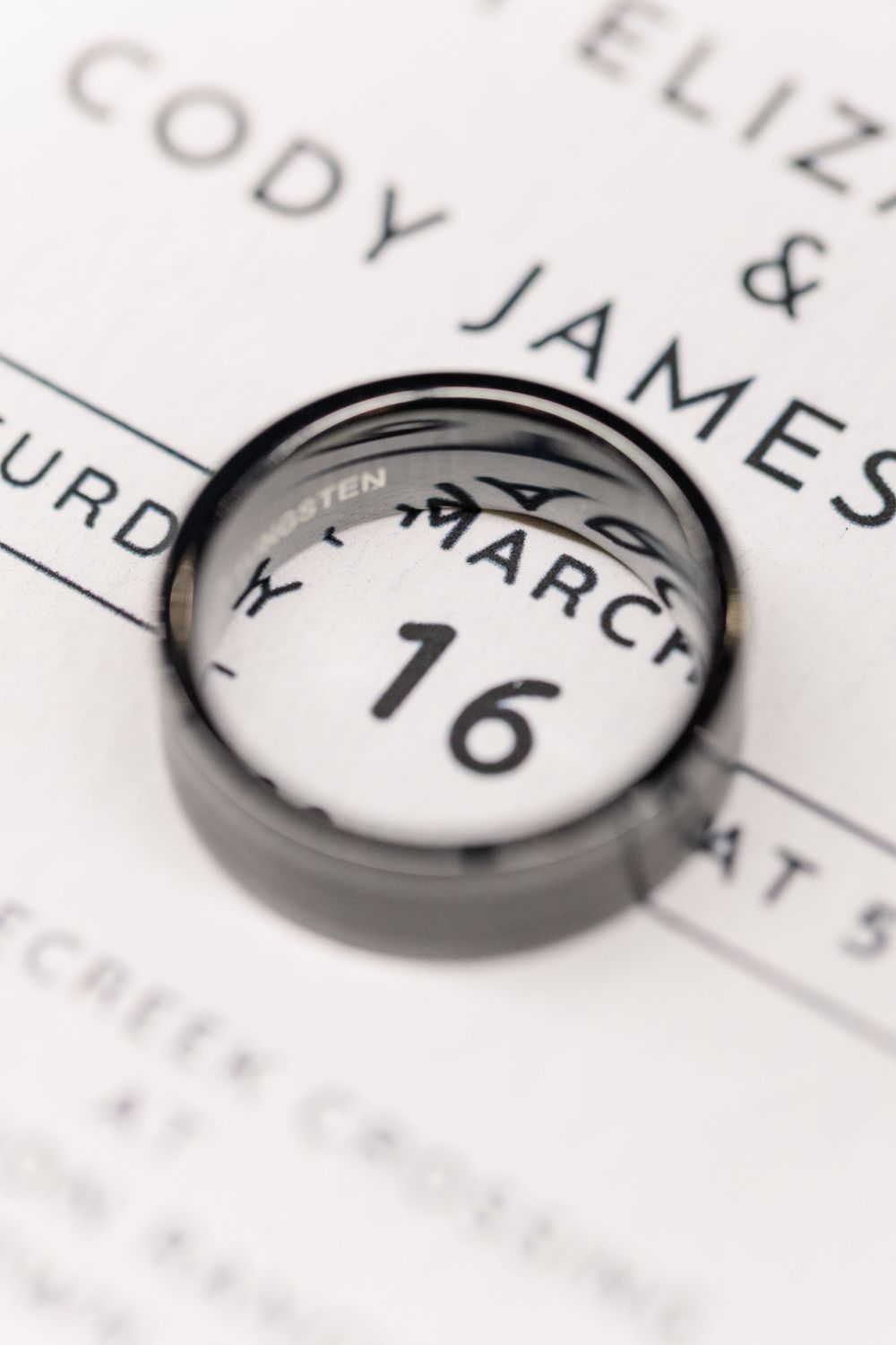 male wedding ring on wedding invitation